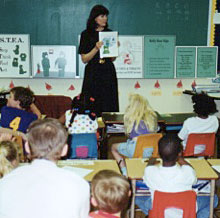 Teacher with Kelly Bear CARES program posters